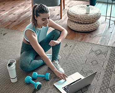 Jeune femme faisant une activité sportive dans son salon