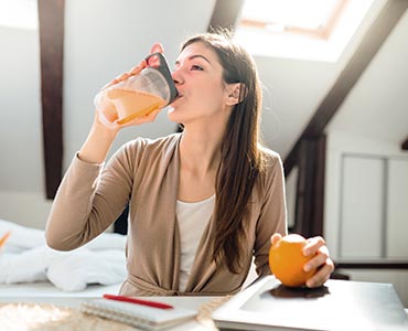 Jeune femme buvant un jus vitaminé