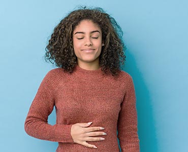 Jeune femme qui se touche le ventre