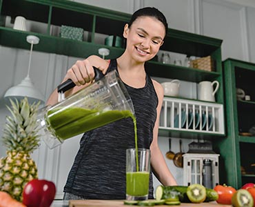 Jeune femme se versant un jus détox