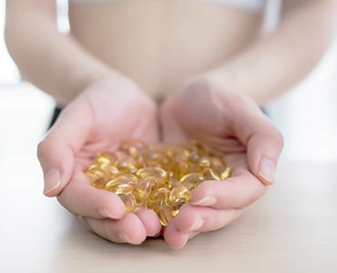 Jeune femme tenant les meilleurs omega 3 au creux de la main