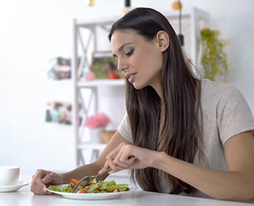 Jeune femme mangeant une assiette "healthy"