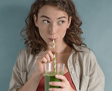 Jeune femme buvant un jus détox