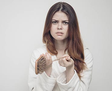 Jeune femme quipert ses cheveux lors du brossage