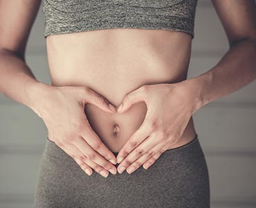 Jeune femme les mains posées sur le ventre