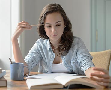 Jeune femme concentrée lisant un livre