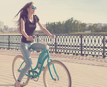 Jeune femme qui fait du vélo en bord de rive