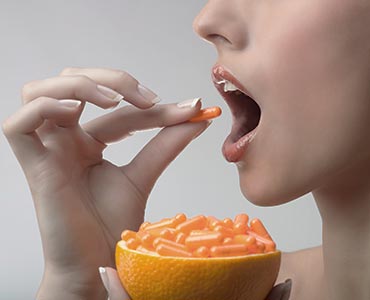 Femme qui prend des gélules de vitamine C