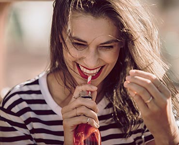 Jeune femme qui boit un soda