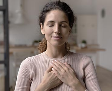 Jeune femme les mains posées sur sa poitrine