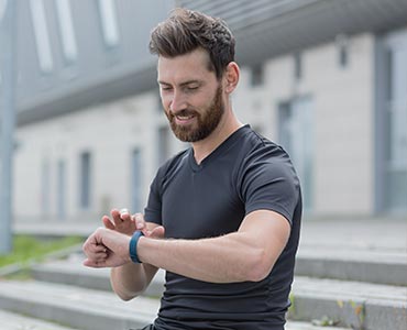 Homme sportif qui regarde sa fréquence cardiaque sur sa montre connectée