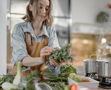 Jeune femme cuisinant un plat équilibré