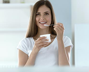 Femme qui mange un produit laitier