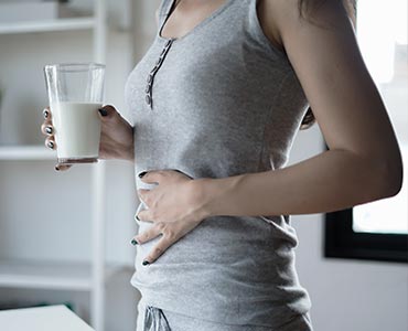 Femme qui digère mal un produit laitier