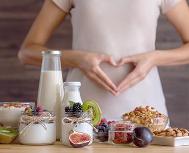 Jeune femme entourée de produits riches en probiotiques