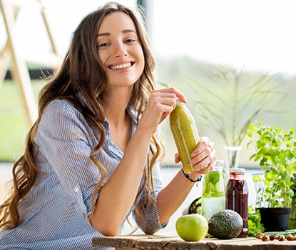 Jeune femme buvant un jus detox