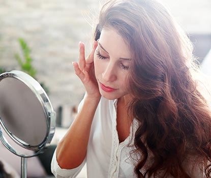 Jeune femme se regardant dans un mirroir