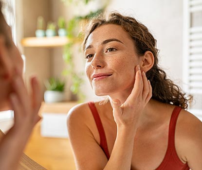 Jeune femme se touchant le visage